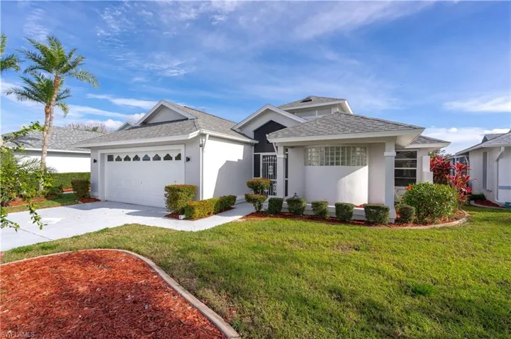 View of front of property featuring a front yard and a garage