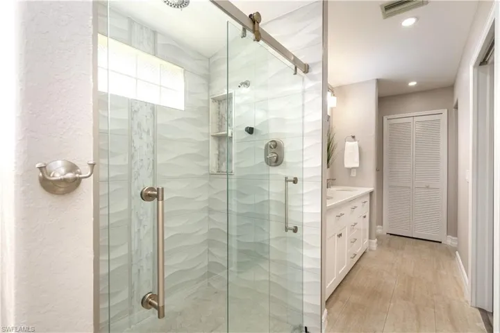 Bathroom featuring walk in shower and vanity