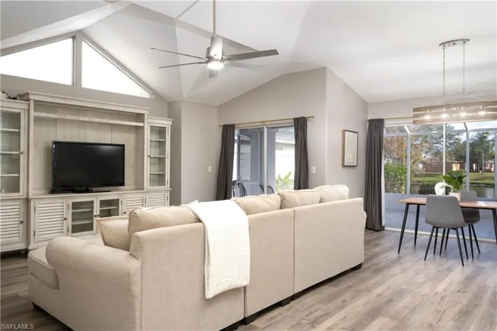 Living room featuring vaulted ceiling, ceiling fan, and hardwood / wood-style flooring