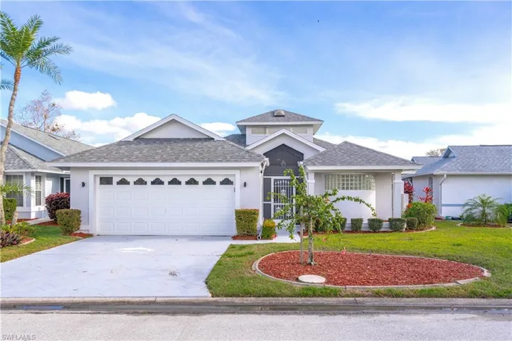View of front of property featuring a garage and a front lawn