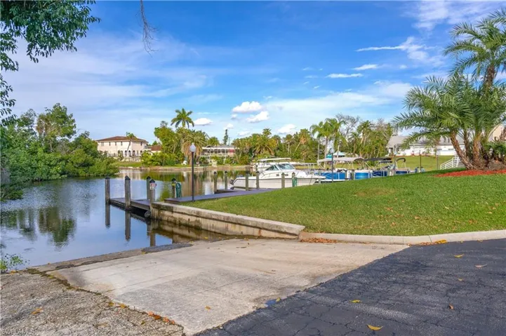 Dock area featuring a water view and a lawn