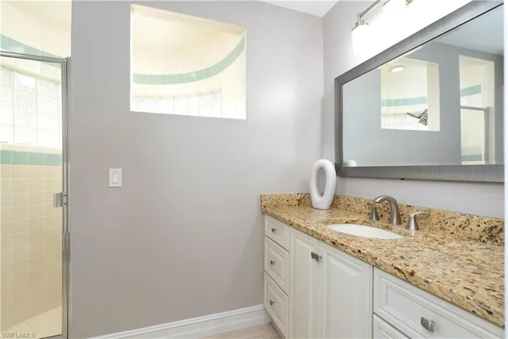 Bathroom with a shower with shower door and vanity
