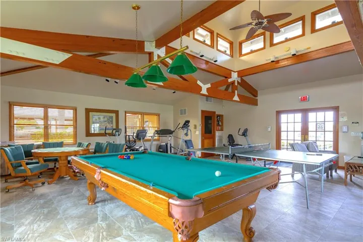 Game room with beam ceiling, ceiling fan, a wealth of natural light, and high vaulted ceiling
