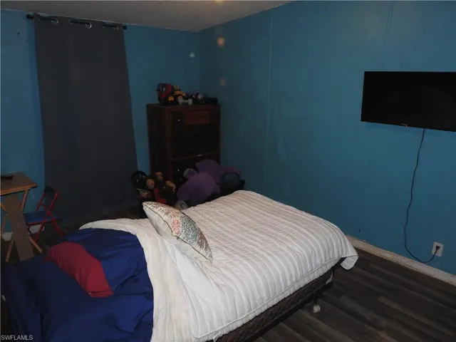 Bedroom with dark wood-type flooring