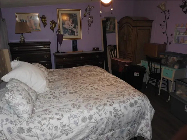 Bedroom with dark hardwood / wood-style flooring