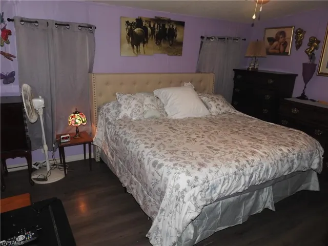 Bedroom with dark hardwood / wood-style floors
