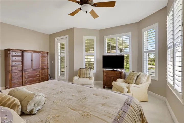 Carpeted bedroom featuring ceiling fan and access to outside