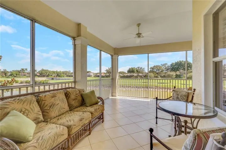 Sunroom with tile patterned flooring and a water view
