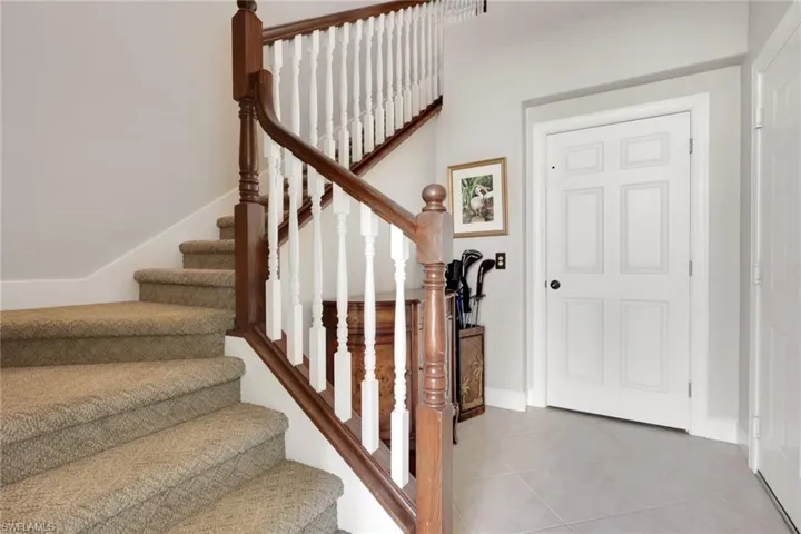 Staircase featuring tile patterned flooring and baseboards