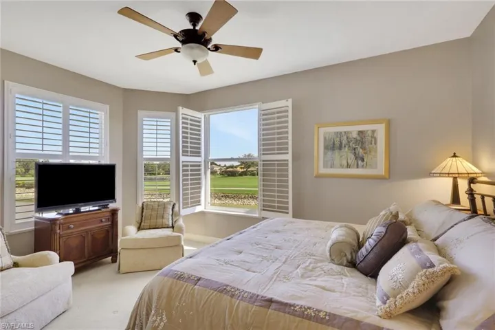Carpeted bedroom with a ceiling fan