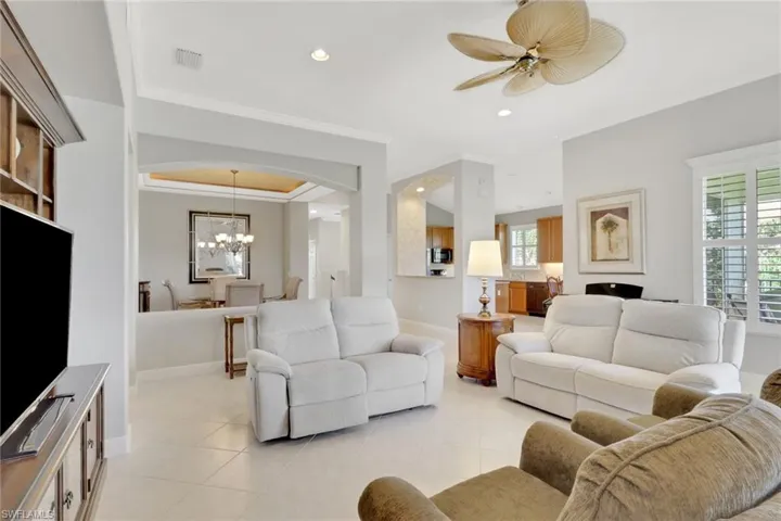 Living area featuring recessed lighting, light tile patterned flooring, arched walkways, a ceiling fan, and a chandelier