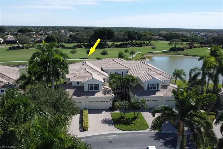 Aerial perspective of suburban area featuring a local golf course and a nearby body of water