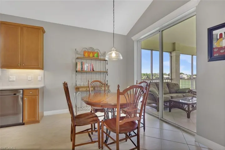 Dining area featuring light tile patterned floors and vaulted ceiling