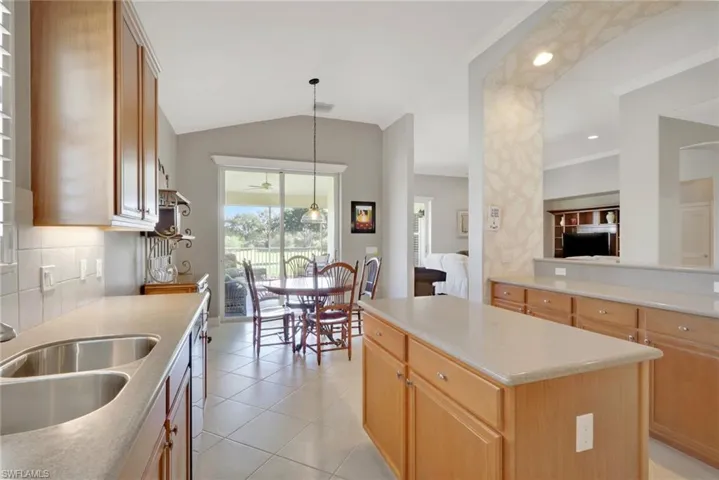 Kitchen featuring hanging light fixtures, a center island, tasteful backsplash, light tile patterned floors, and recessed lighting