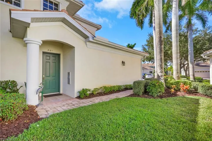 Doorway to property with stucco siding and a lawn