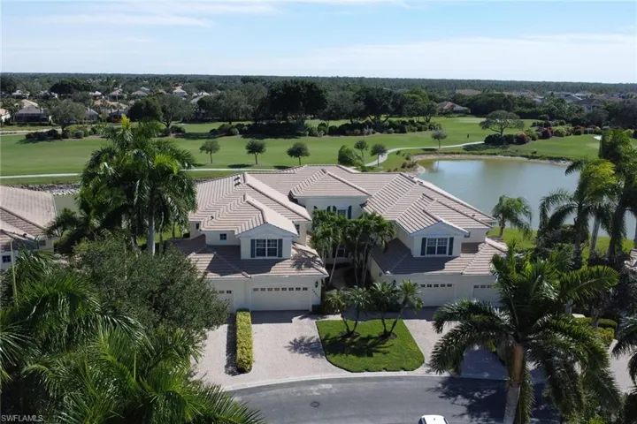 Aerial view of residential area featuring a golf club and a nearby body of water