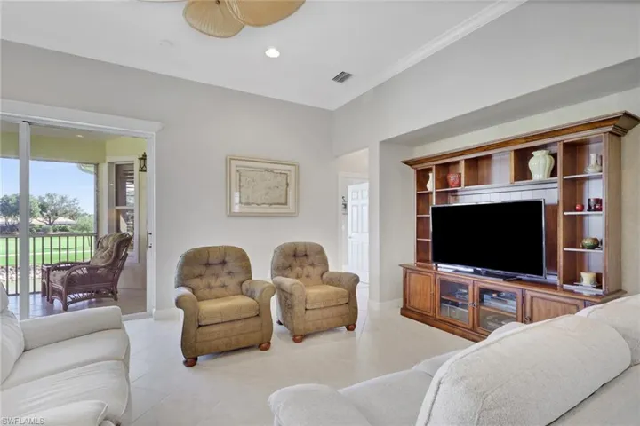 Living area with recessed lighting, light tile patterned floors, and crown molding