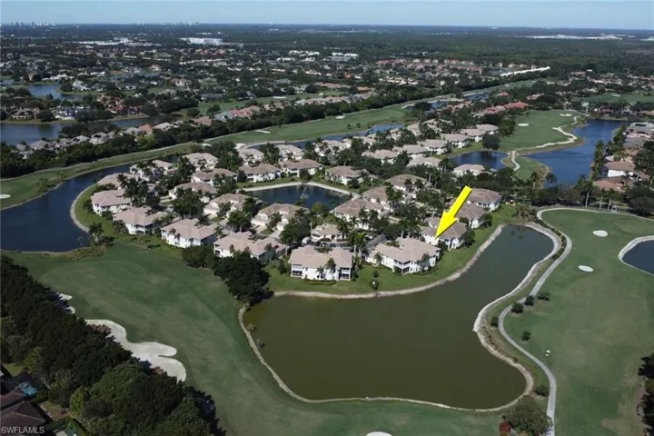 Aerial view of property and surrounding area featuring nearby suburban area and a golf course