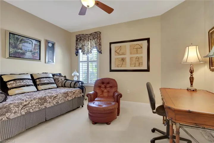 Carpeted bedroom with ceiling fan and baseboards