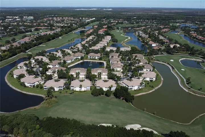 Aerial view of property and surrounding area featuring nearby suburban area and a golf club