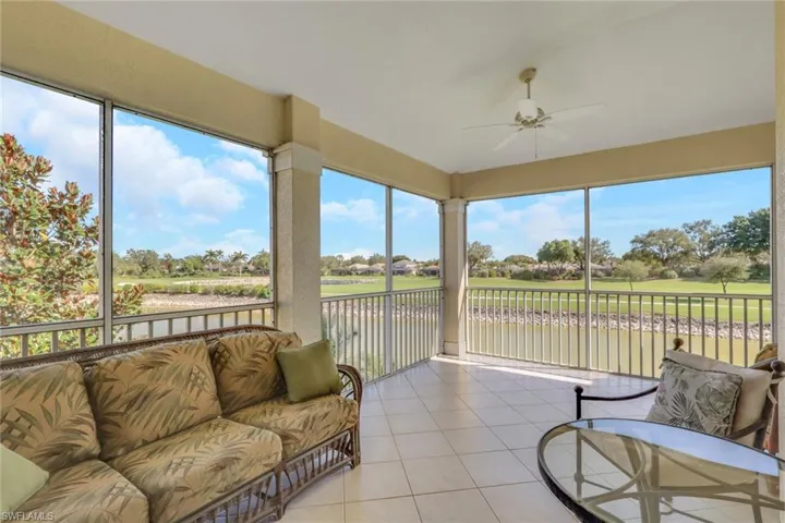 Sunroom featuring tile patterned flooring and a water view