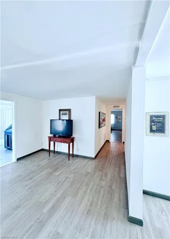 Living room with light wood-style floors and baseboards