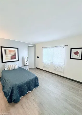Bedroom with light wood-style flooring and an accent wall