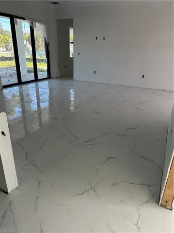 Spare room featuring light marble finish floors
