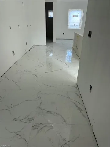Spare room with light marble finish floors
