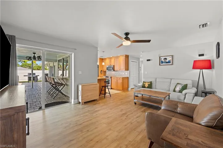Living room with ceiling fan and light hardwood / wood-style flooring
