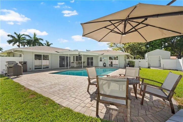 View of pool featuring a grill, a lawn, and a patio area
