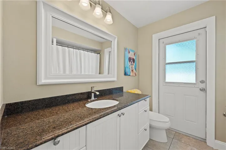 Bathroom featuring tile flooring, vanity, and toilet