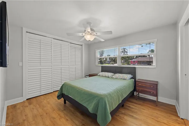 Bedroom with light hardwood / wood-style floors, a closet, and ceiling fan
