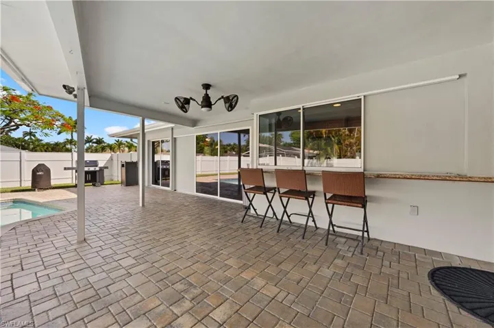 View of patio with an outdoor bar, area for grilling, and a fenced in pool