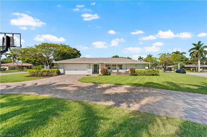 Ranch-style home featuring a garage and a front lawn