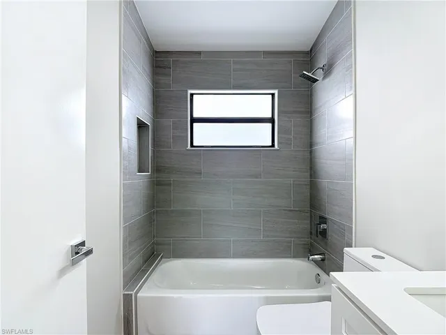 Full bath with toilet, vanity, and bathing tub / shower combination