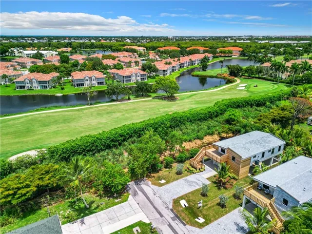 Drone / aerial view featuring golf course view and a water view
