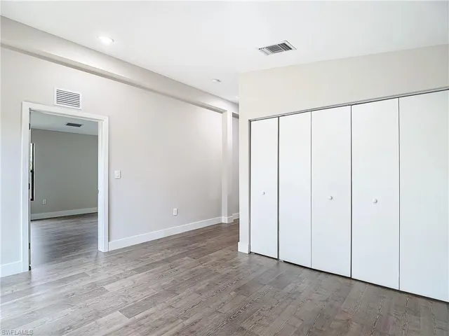 Unfurnished bedroom featuring baseboards, visible vents, a closet, and light wood-style floors