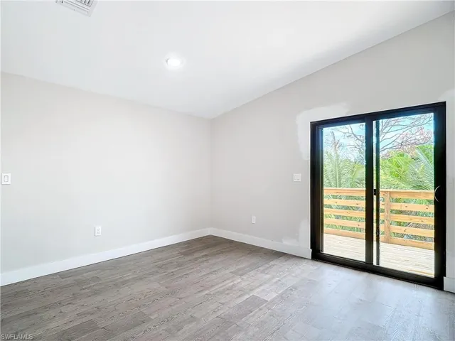 Unfurnished room featuring wood finished floors, baseboards, and visible vents