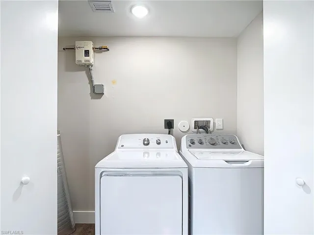 Laundry room with laundry area, visible vents, and separate washer and dryer