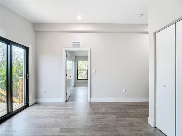 Empty room featuring visible vents, baseboards, and wood finished floors