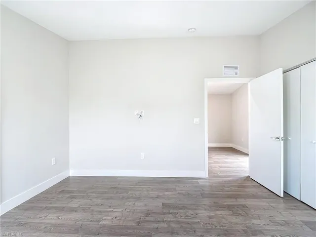 Unfurnished room with baseboards, visible vents, and wood finished floors