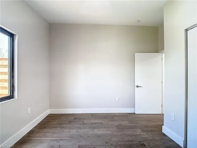Unfurnished room featuring baseboards and wood finished floors