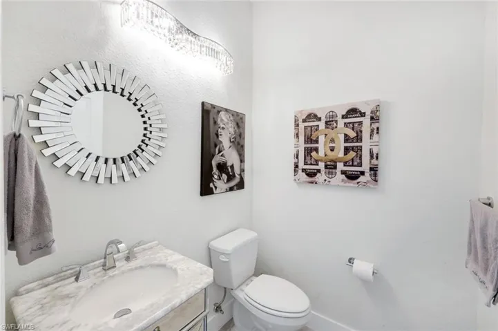 Half bath with vanity and toilet, located just off of the living room