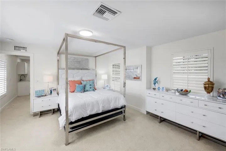 Bedroom featuring light carpet and baseboards