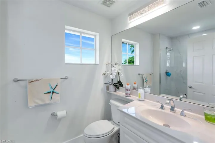 Bathroom featuring vanity and a marble finish shower