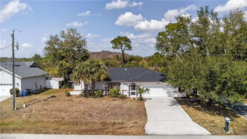 Ranch-style home featuring concrete driveway and a garage