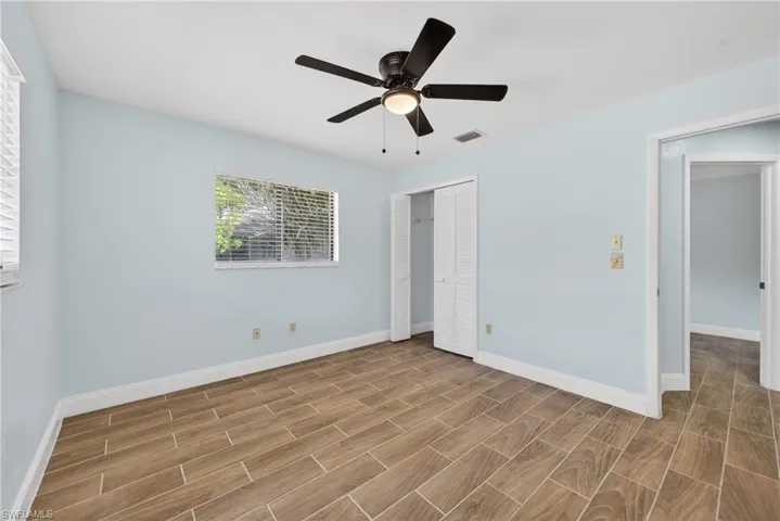 Unfurnished bedroom featuring wood finish floors, ceiling fan, and a closet