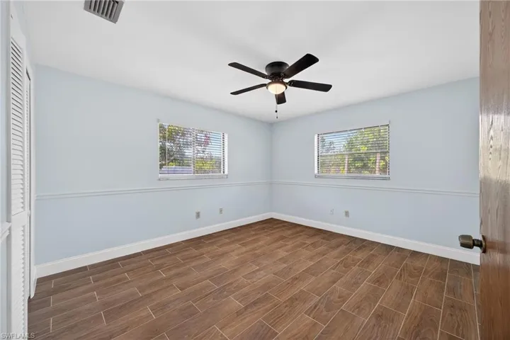 Unfurnished bedroom with wood tiled floors, a ceiling fan, and a closet