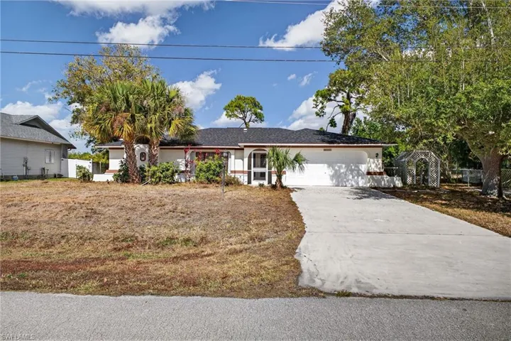 Ranch-style home featuring an attached garage and driveway